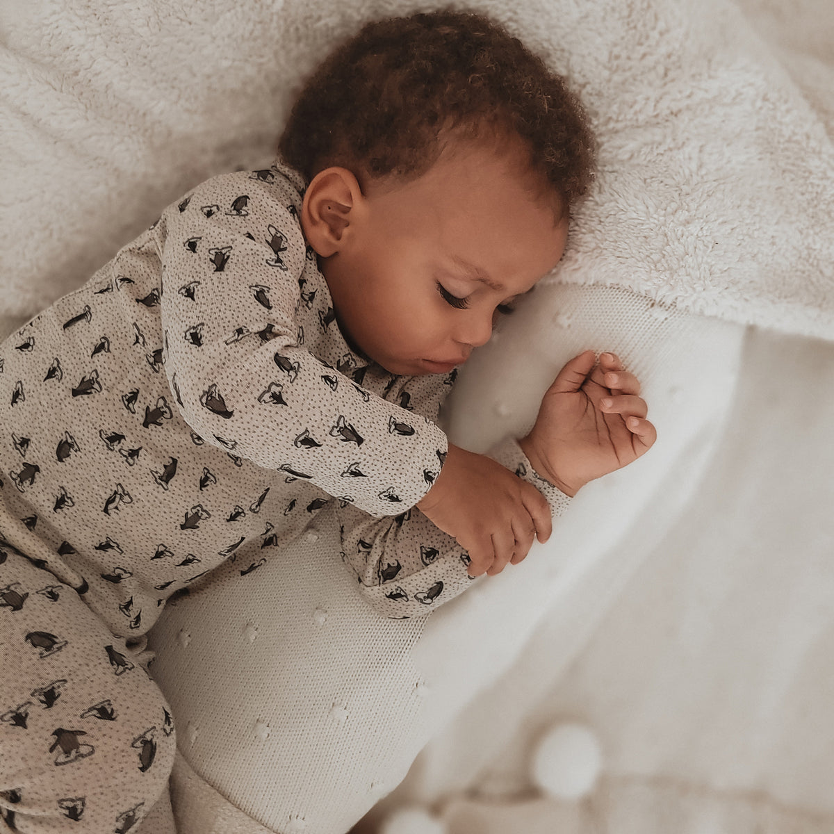 Sleeping baby in a printed bodysuit